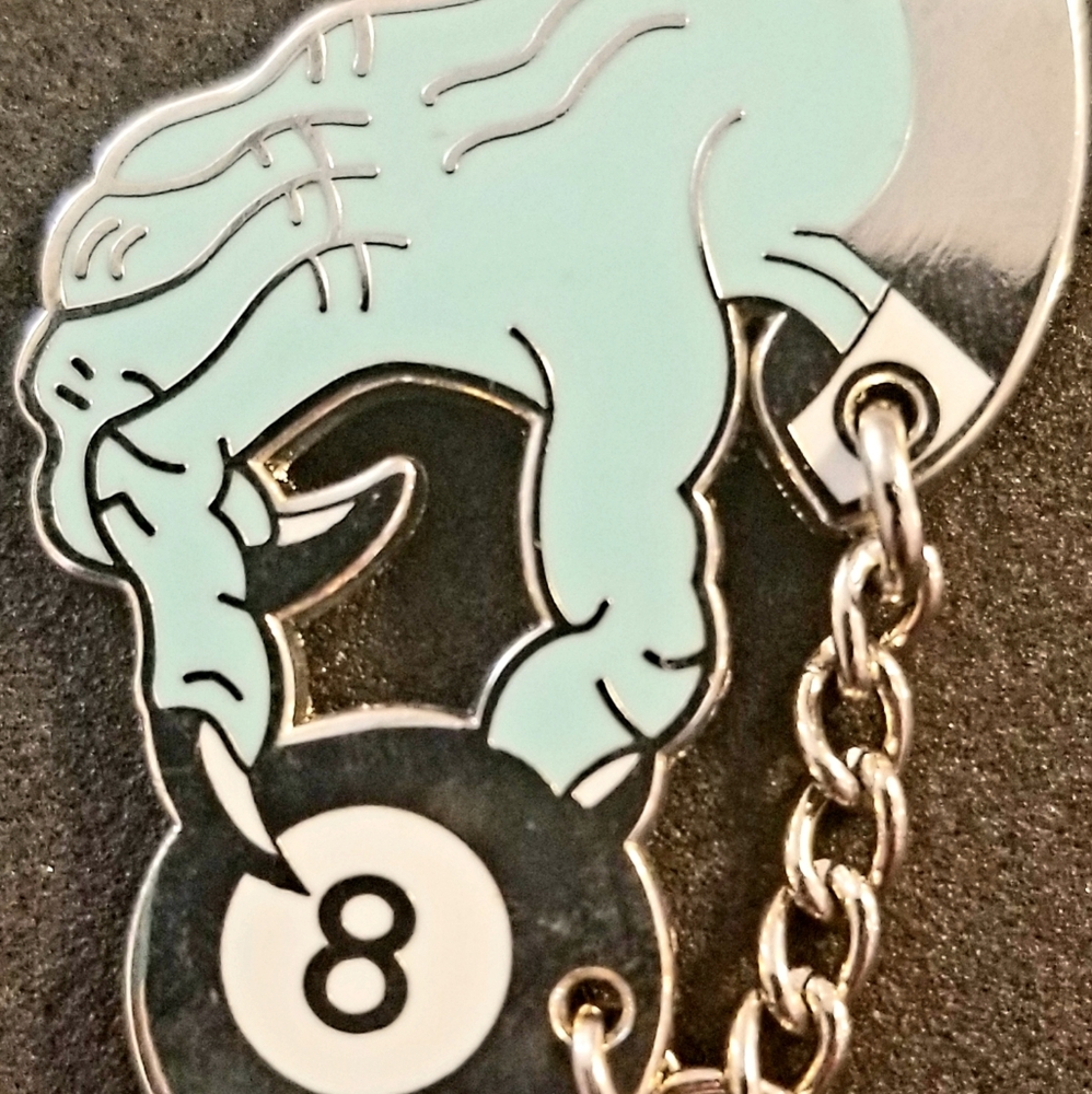 Hand chained to magic 8 ball pin